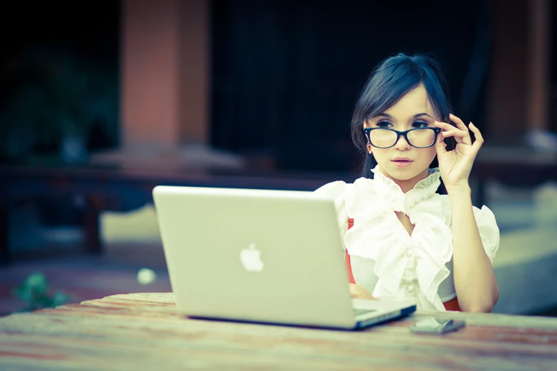 the woman is using her laptop while talking on the phone