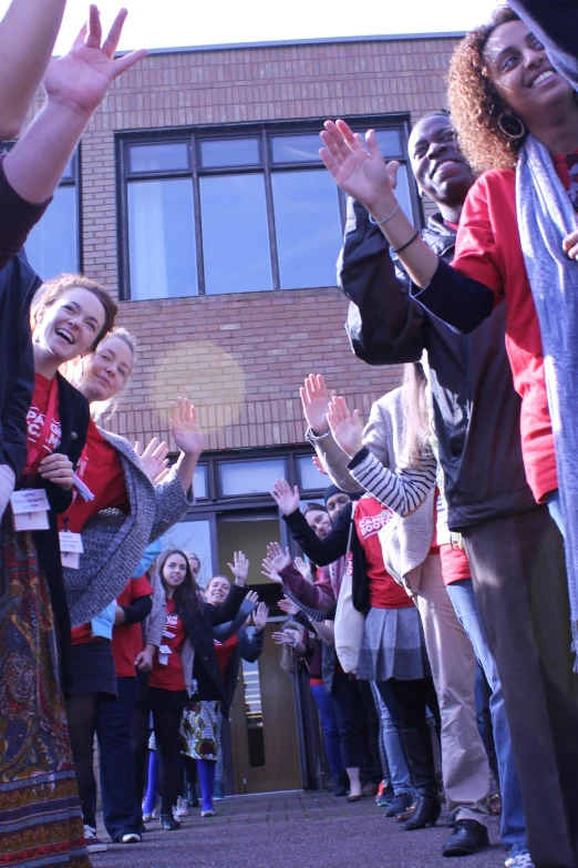 group of young people applauding a woman while another person waits to catch an item