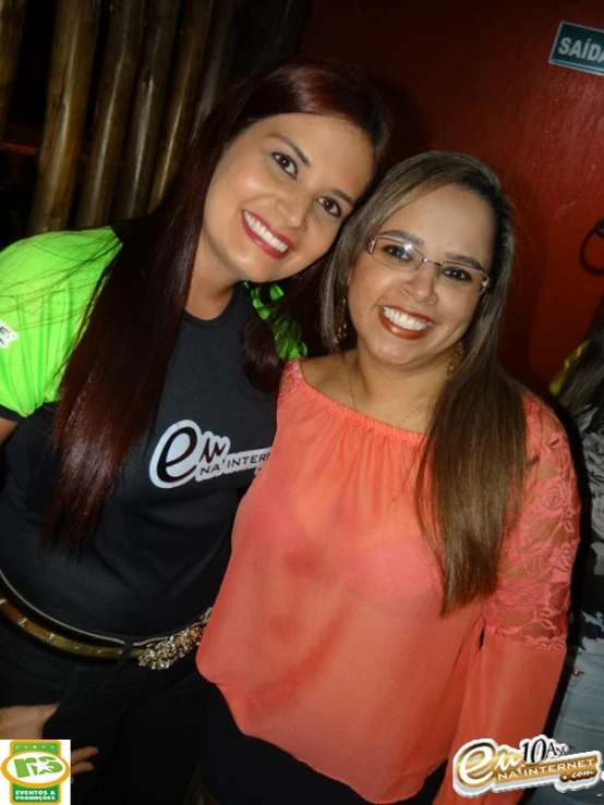 two girls smiling for the camera in a public place