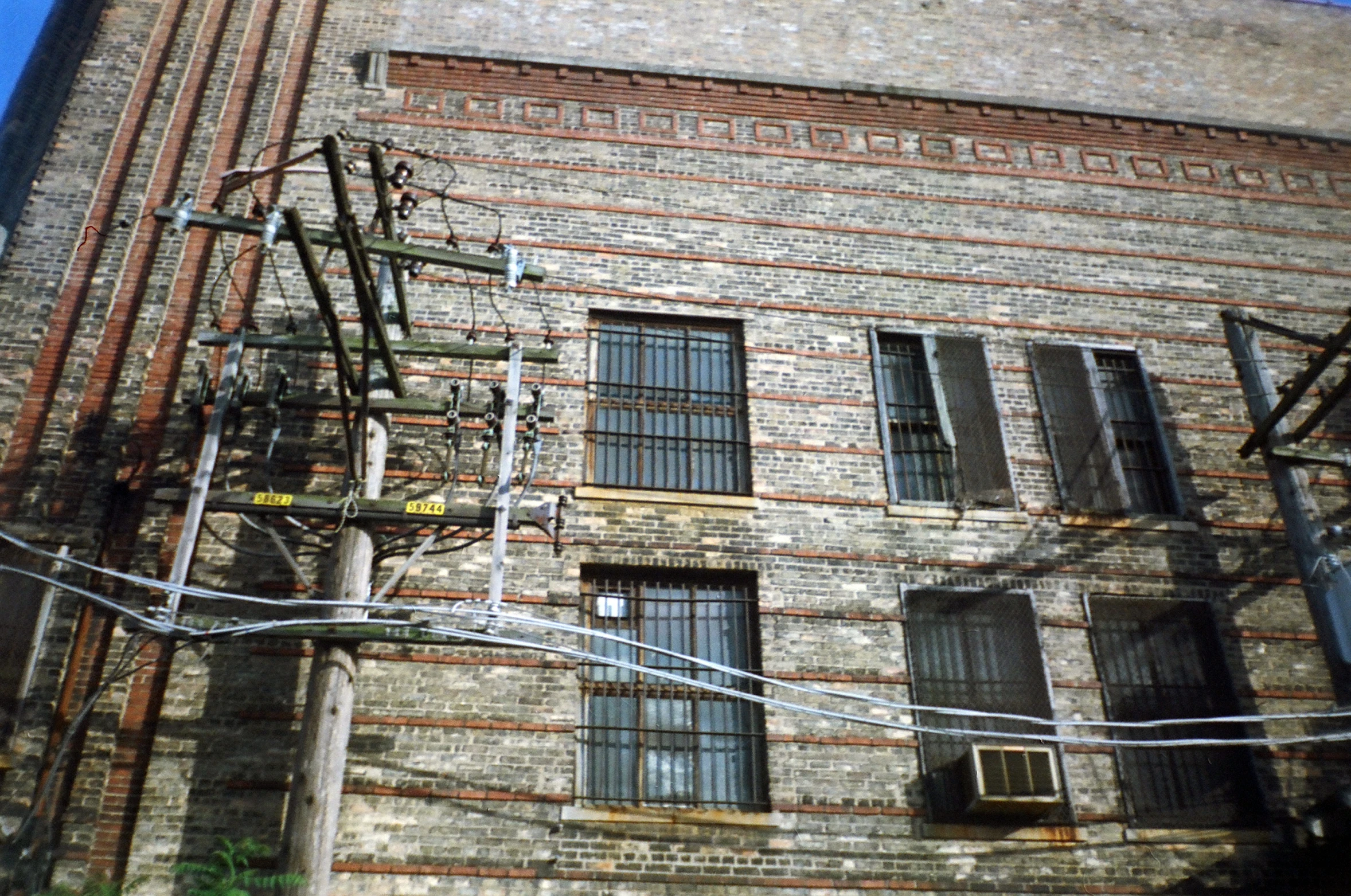 a large brick building is behind a wire pole