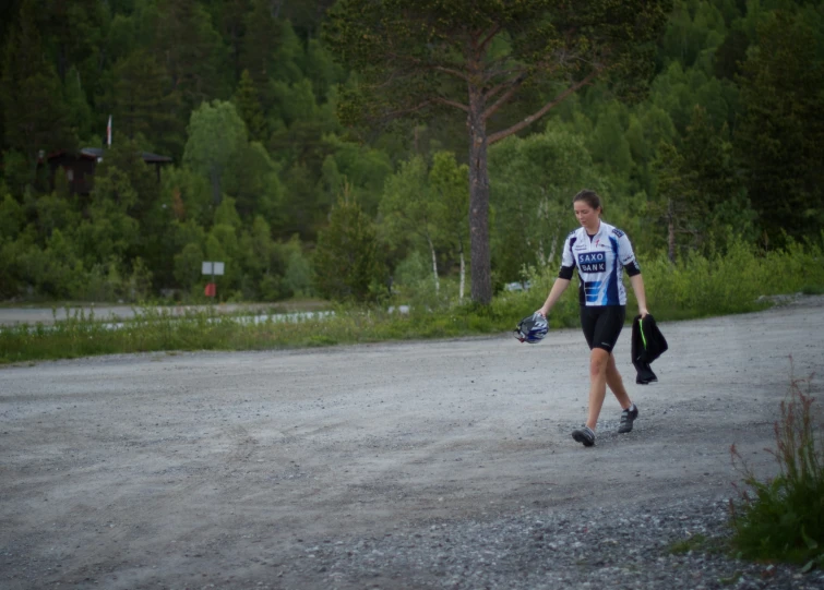 a man walking down a road with two bags and gloves on