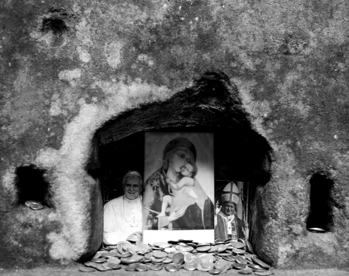 an old stone cave has a picture of jesus and two people