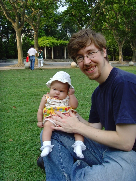 a man holding a baby in the park