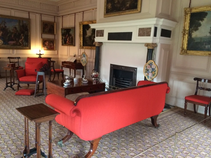 an antique style sitting room with red chairs