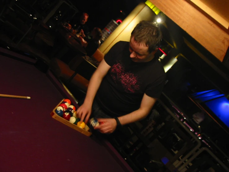 a man holds a game of billiards in his hands