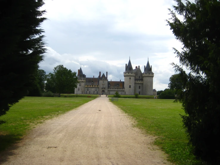 a road is leading towards an old mansion