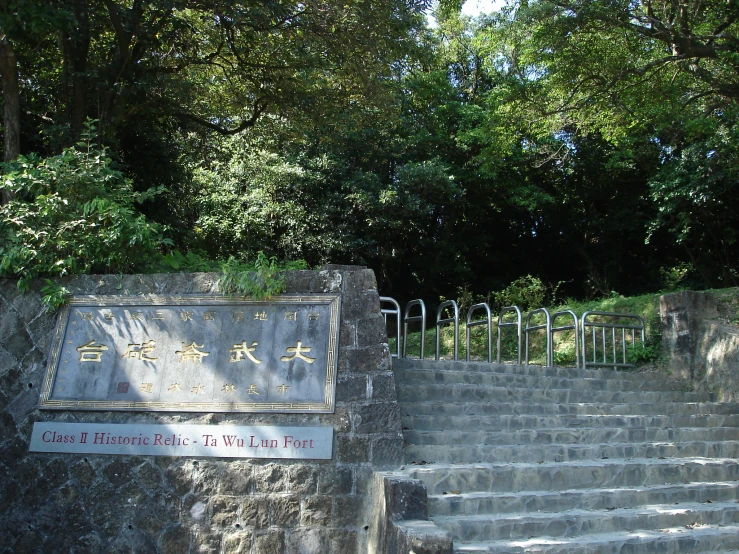 a large sign on a stone wall next to steps