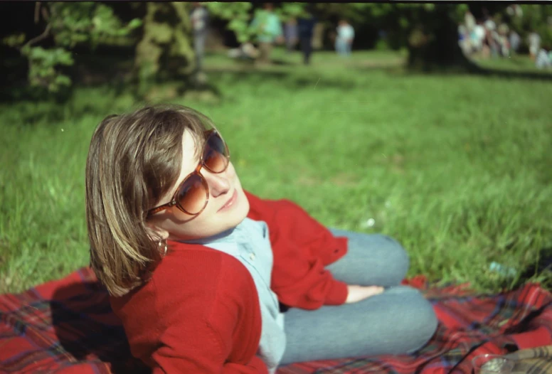 a small girl is laying on a red and white blanket