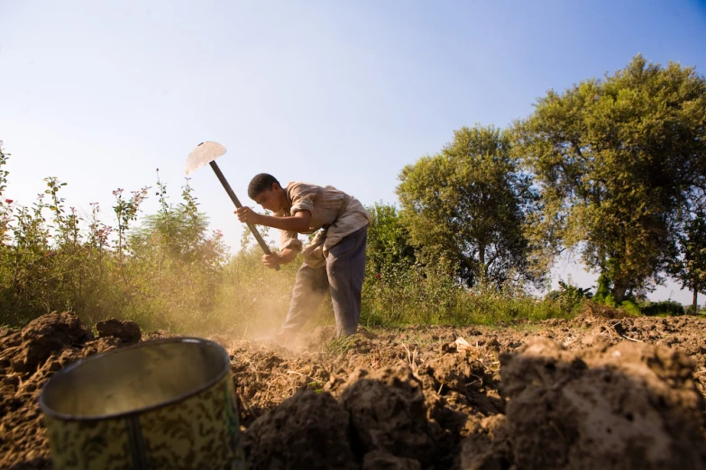 a man using a shovel and bucket to dig the ground