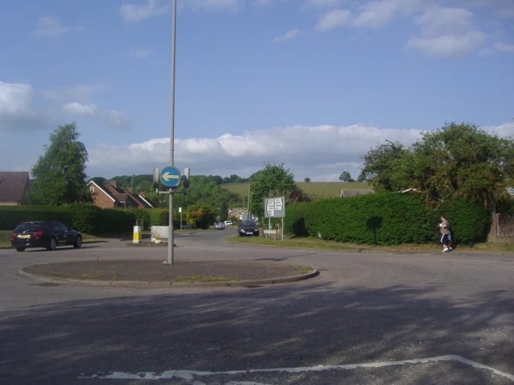 an intersection in a residential neighborhood with cars parked on it