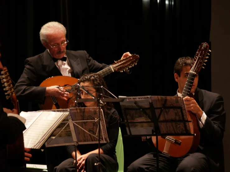 four musicians with instruments are performing for audience