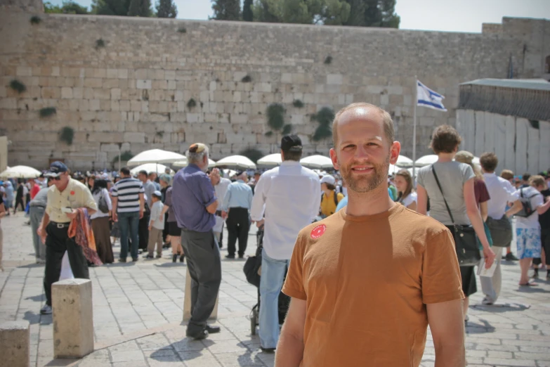 a man with an umbrella standing in a crowded plaza