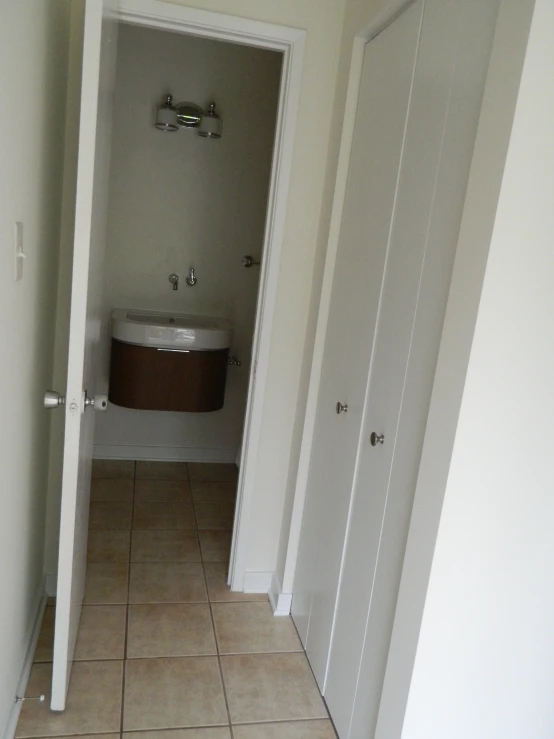 a bathroom with tile floors, tiled walls, and two separate doors