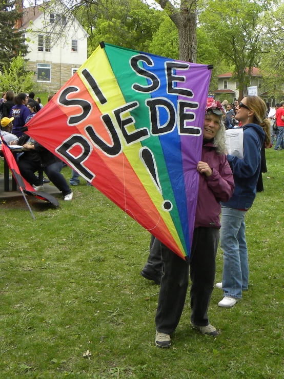 a person holding up a colorful kite that says see benedict