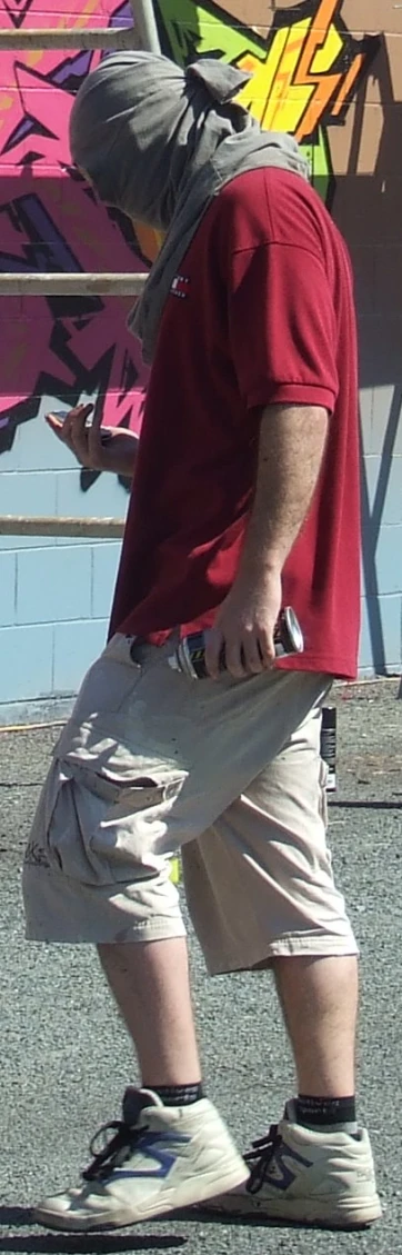 a man in front of a wall with graffiti on it