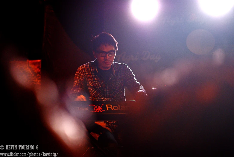 man sitting at table looking at cellphone while on stage