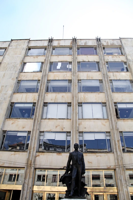 a statue stands in front of the side of an old building