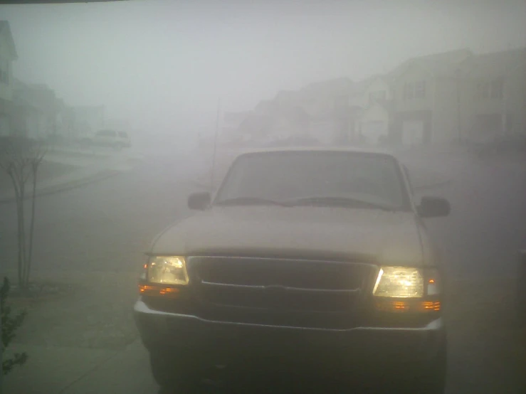 the truck is in the fog on a city street