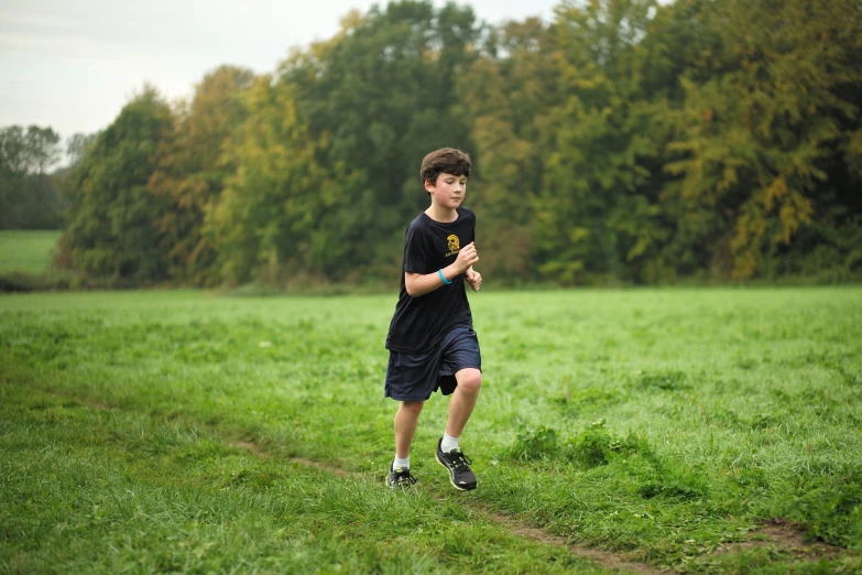 a boy in a park walking through the grass