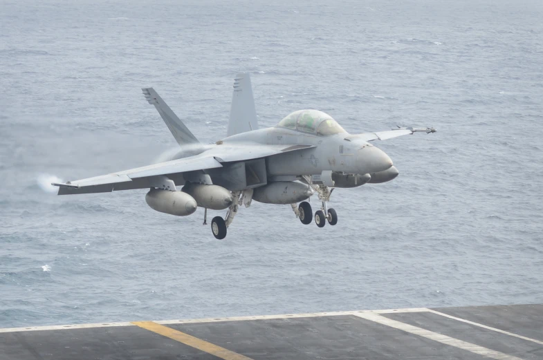 a military plane flying over the ocean