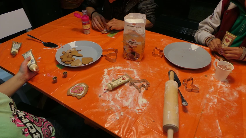 people sit and cook on an orange table