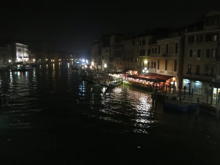 boats are in the water at night in front of buildings