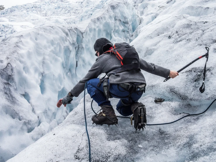 a man in the mountains is holding on to some ropes