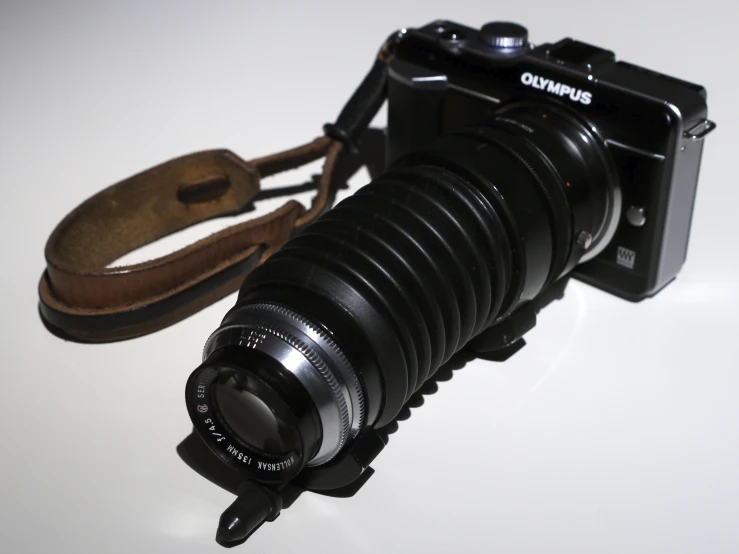 a very old camera laying next to a leather case