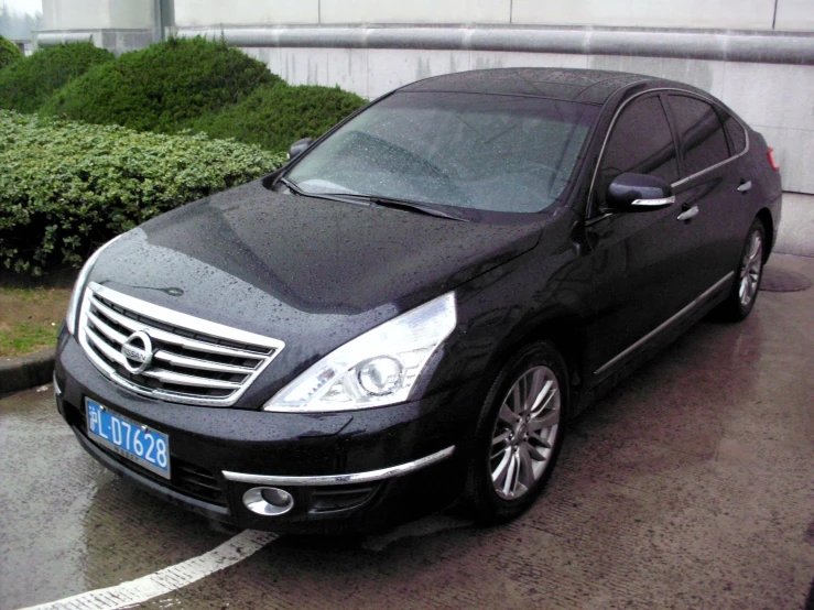 a black mercedes benz car parked next to a tree