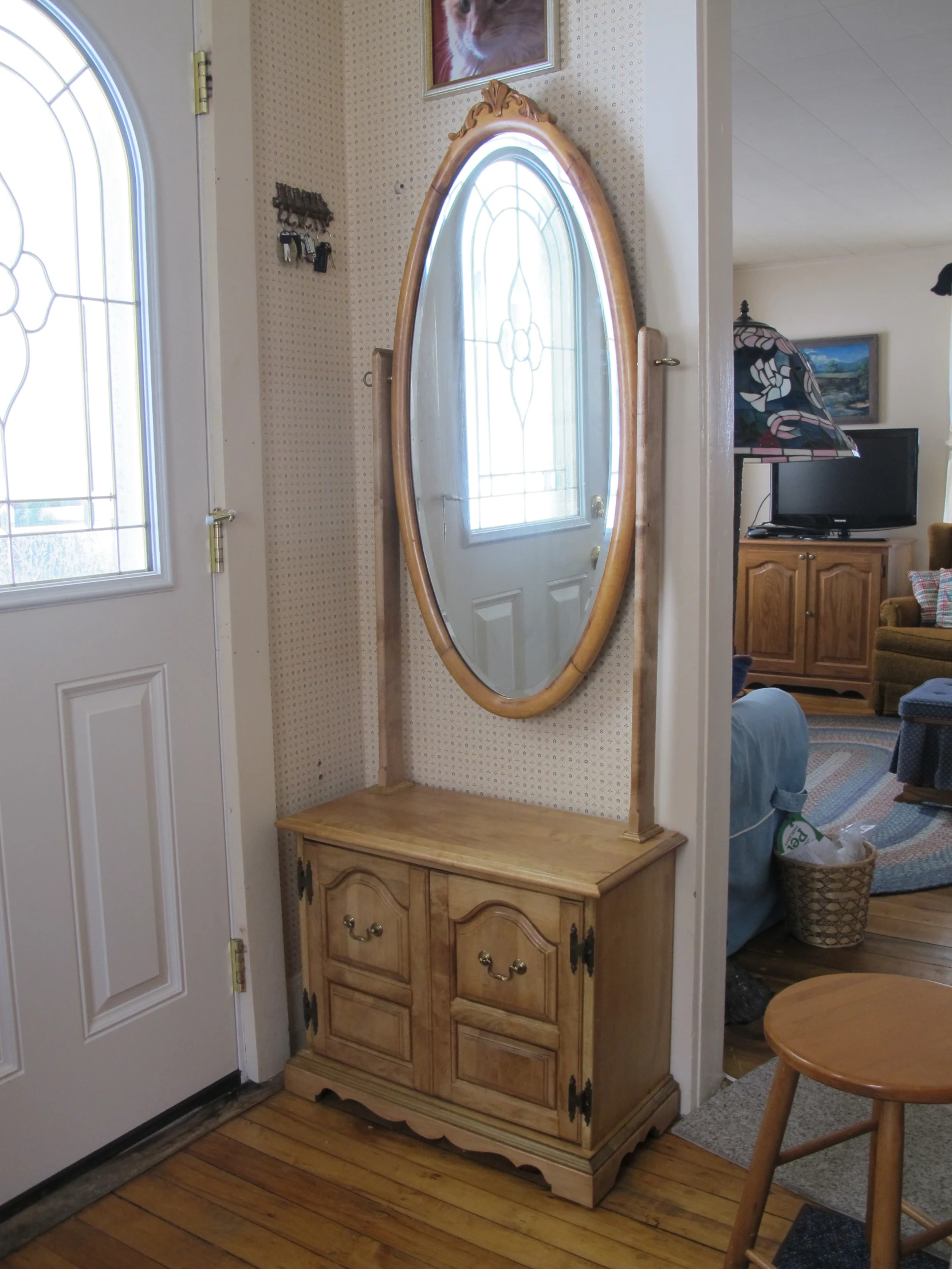 a small dresser with a large mirror in front of it