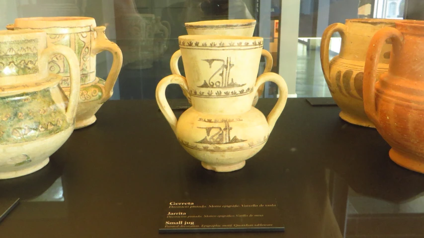 some old glass vases on display in a case