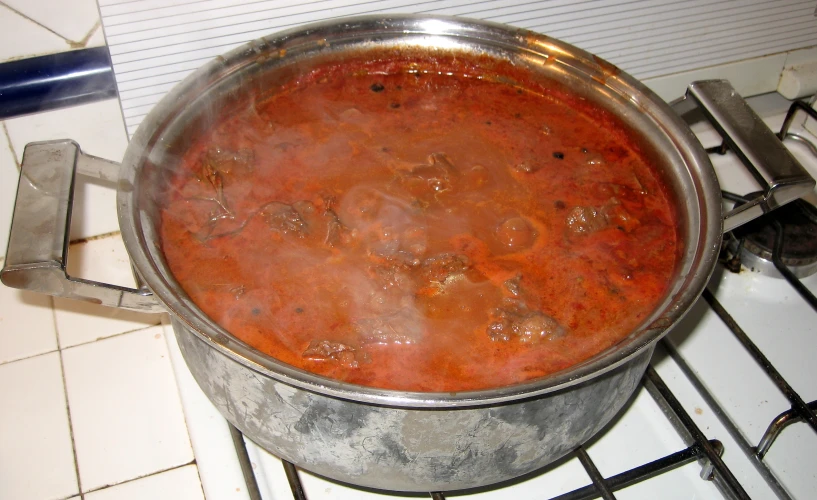 a large pot on the stove is filled with soup