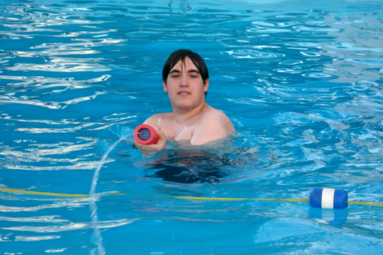 a man holding a water gun in a swimming pool