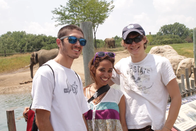 a couple of friends at a zoo posing for a po