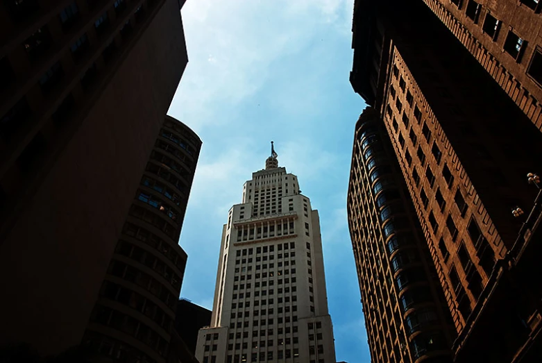 a tall skyscr is visible through the middle of two buildings