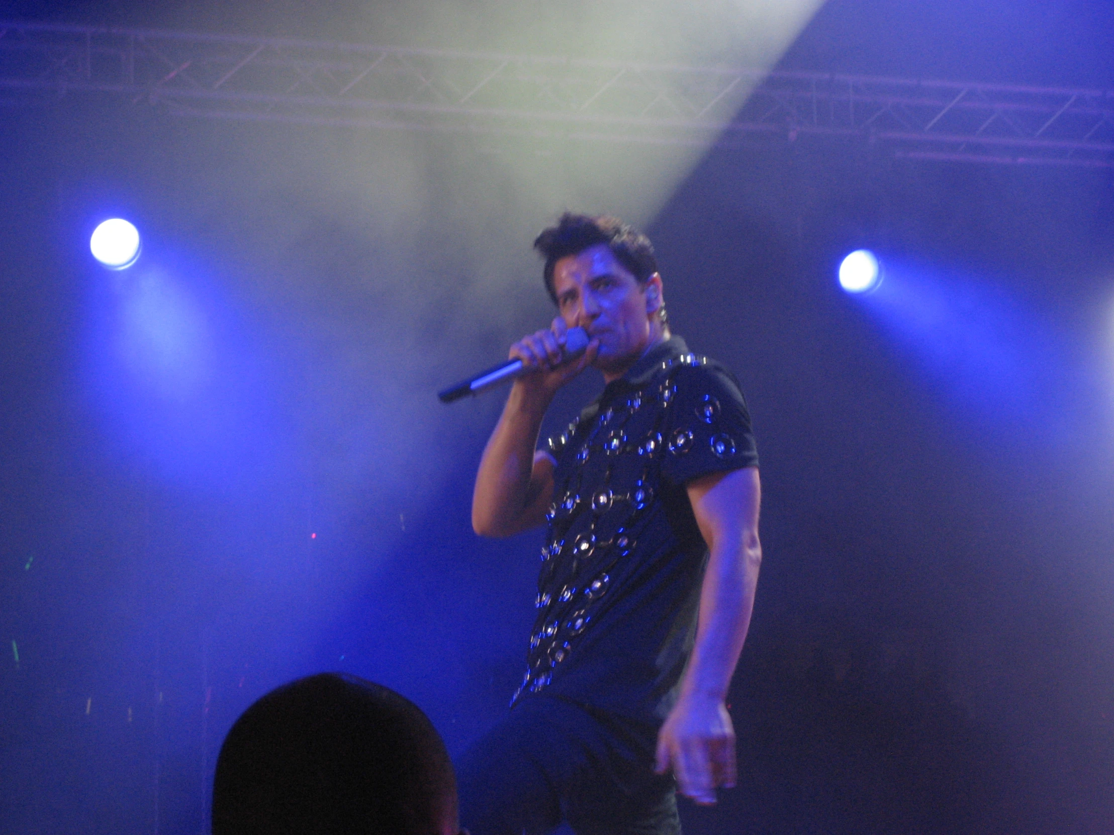 a man on stage performing a song with microphone