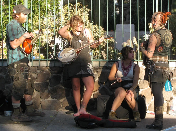 some people sit on the side walk with guitars