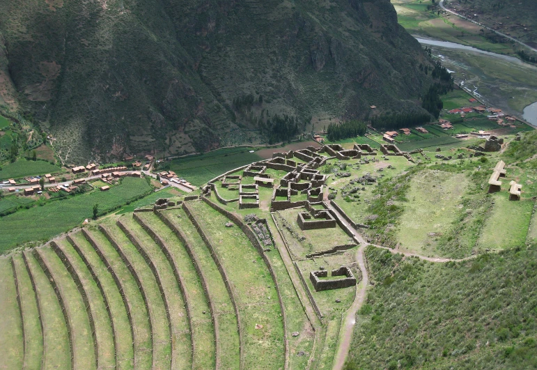 a village near the mountains is built on top of grass