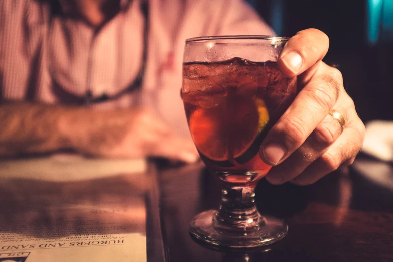 a man holds up a drink in front of the camera