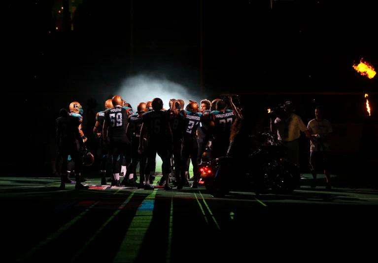 the teams are gathered in the dark for a game