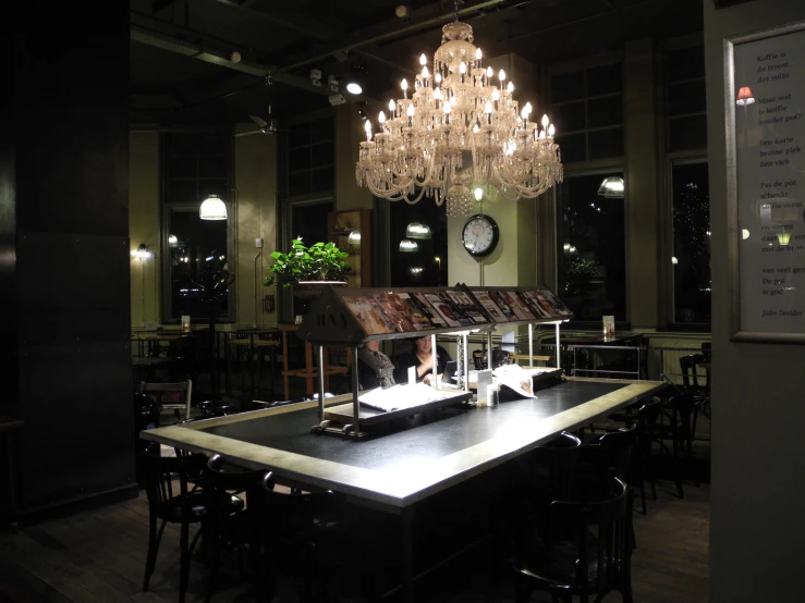 a dark restaurant, with a chandelier above the counter