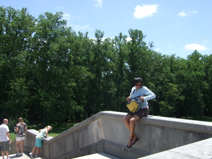 a woman standing next to a railing while looking at her cell phone