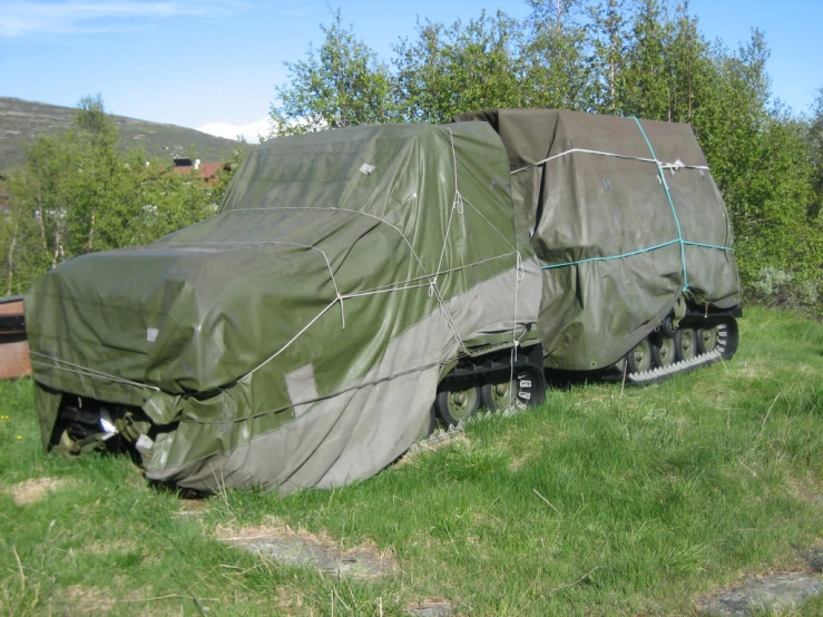 a big covered truck is sitting in the grass