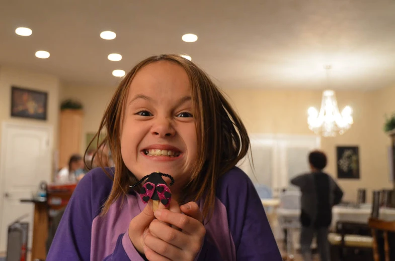 a little girl is eating soing in the kitchen