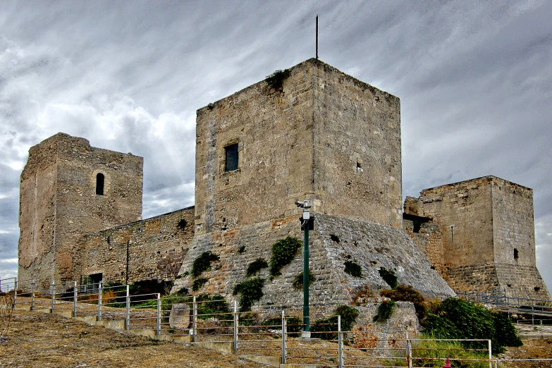 an old castle style building sits atop a hill