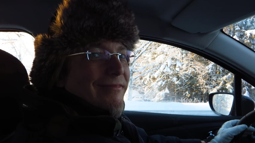 a man driving with his car in the front seat