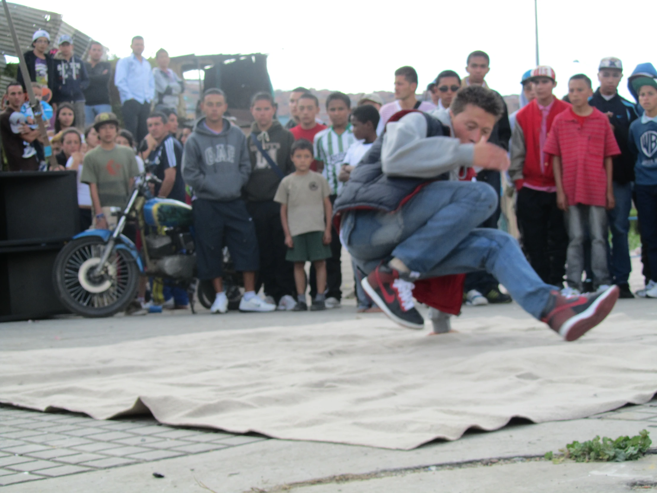 a young man is performing a stunt on a blanket with other people