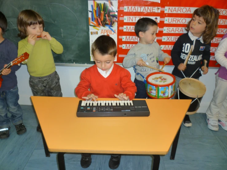 small children standing in front of a piano