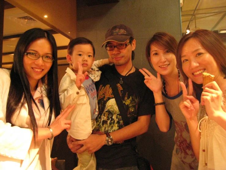 a group of people making a peace sign with their fingers