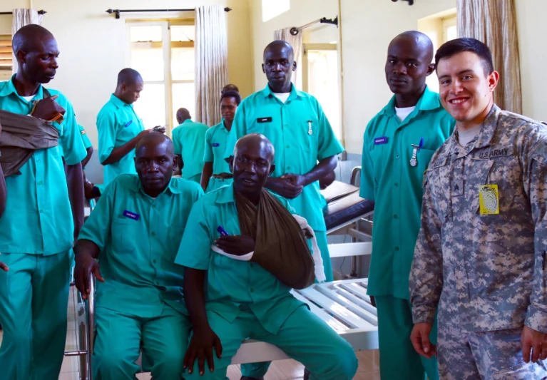 four men in green uniforms pose together for the camera